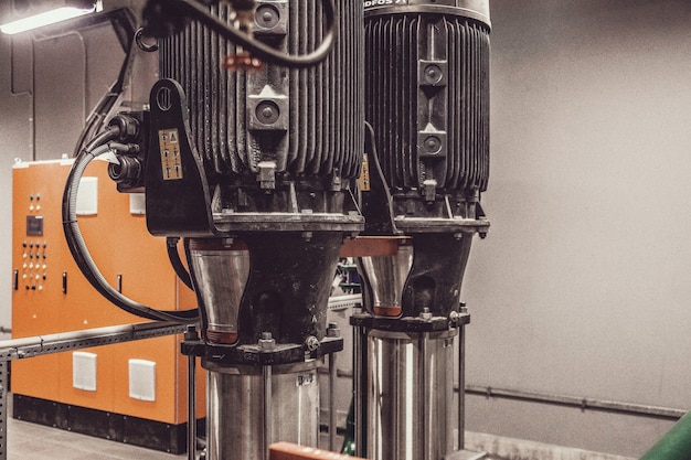 Photo contains film grain. Water pump station and pipeline with tanks in an industrial room to supply high pressure water for firefight tasks. Sprinkler pipes and control system to provide drink water