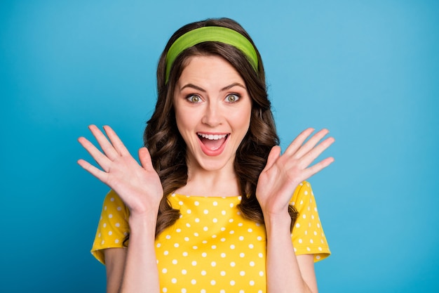 Foto foto di una giovane donna pazza e stupita che grida forte alza le mani indossando abiti a pois isolati su uno sfondo di colore blu