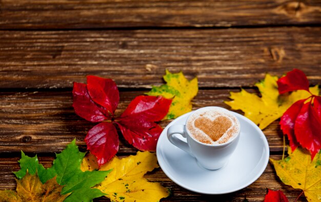 Photo of cup of coffee and autumn leaves