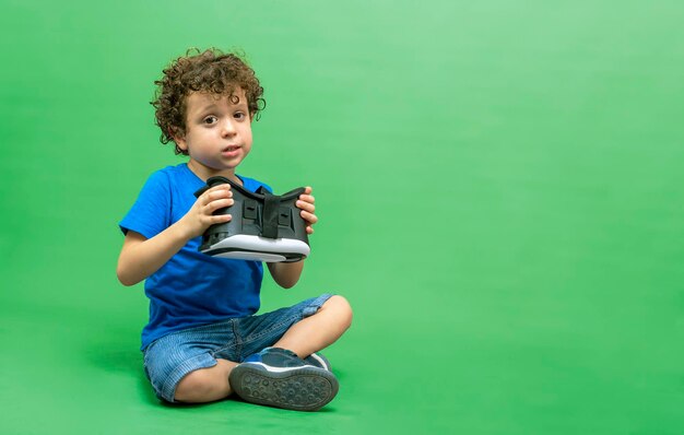 Photo of curlyhaired caucasian boy wearing virtual reality glasses