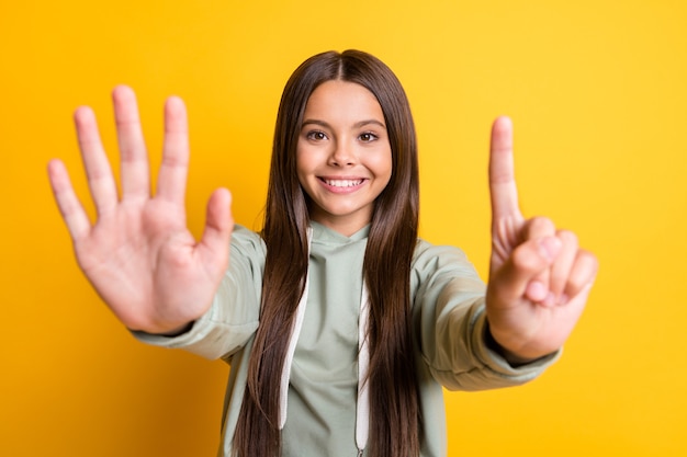 Photo of cute adorable school girl wear casual grey outfit showing palm counting six isolated yellow color background