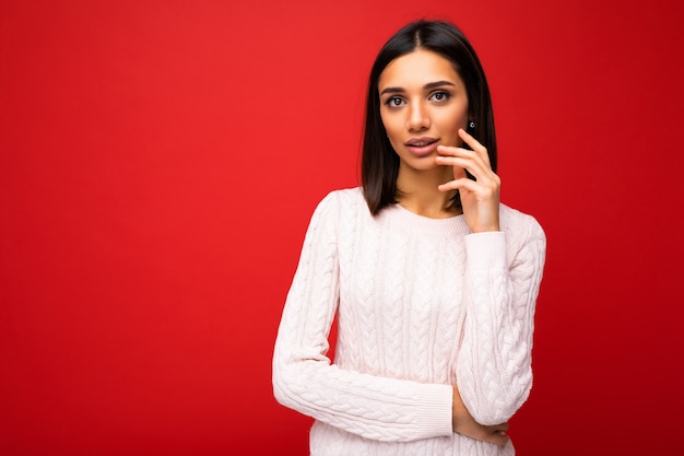 Foto di una bella donna adulta positiva e accattivante che indossa abiti casual isolati su una parete di fondo