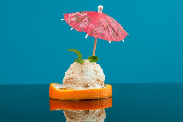 Photo of cutted orange with ice cream and mint on it. Shallow depth-of-field