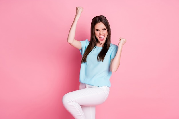 Photo of delighted girl lottery lucky win raise fists scream isolated over pink color background
