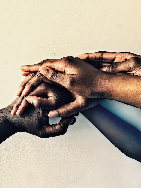Photo of different hands coming together to show togetherness as a team a family or a group