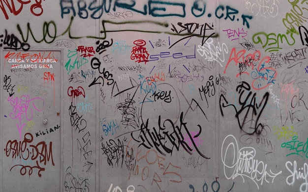 Photo of a dirty outdoor metal fence painted with graffiti