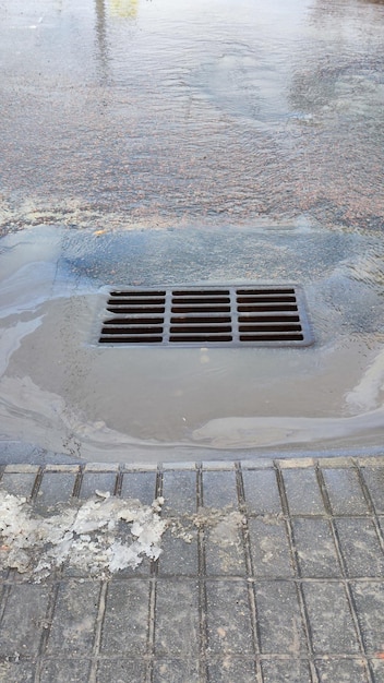 汚水が道路を下水道に流れている写真