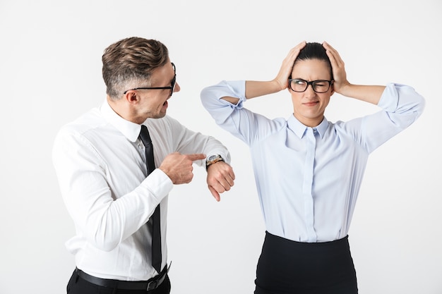 Foto foto delle coppie arrabbiate dispiaciute dei colleghi di lavoro di litigio isolate sopra l'orologio di rappresentazione della parete bianca.