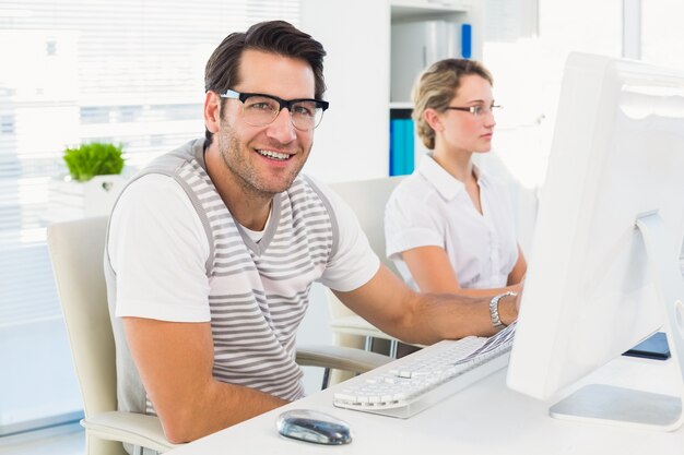 Photo editor sitting at desk looking at camera