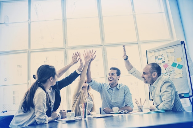 Photo editors high-five in meeting room