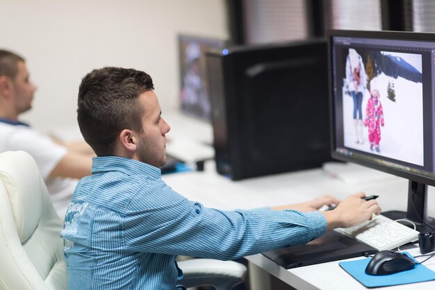 photo editors working with graphic tablet and pen on photographs in retouching studio