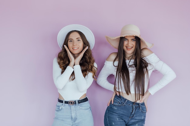 Photo of emotional two women friends standing isolated over purple background.