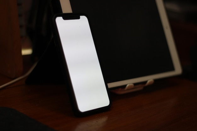 Photo of an empty cell phone with white screen on the table