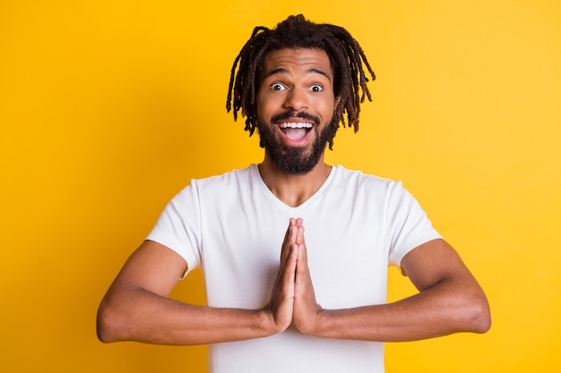 Photo of excited dark skin guy hold arms together begging friend play video game wear t-shirt isolated yellow color background