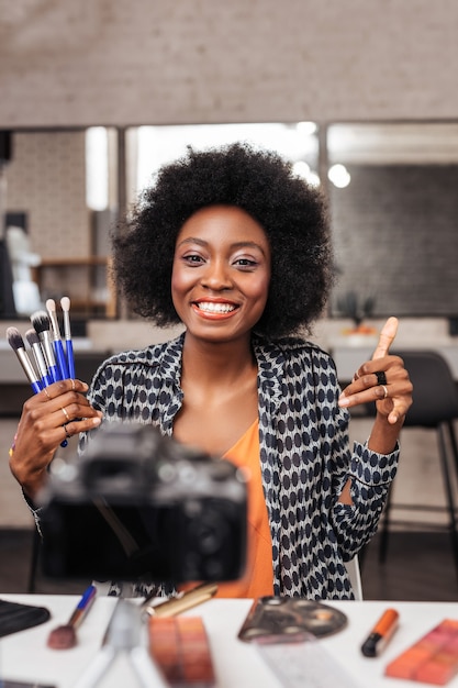 Photo for fashion magazine. Cute woman with curly hair feeling amazing while making photo for fashion magazine