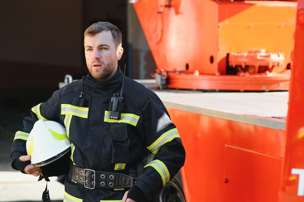 Photo of fireman with gas mask and helmet near fire engine