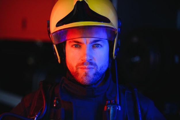 Photo of fireman with gas mask and helmet near fire engine