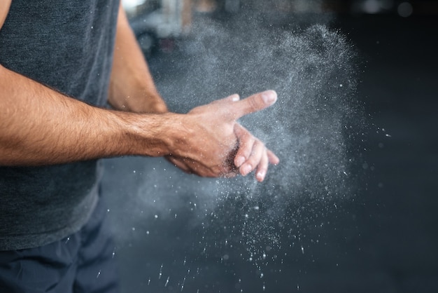 Photo of fitness hands. rubbing hands with chalk