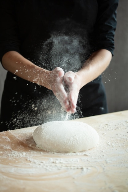 Photo of flour and men hands with flour splash. Cooking bread. Kneading the Dough.