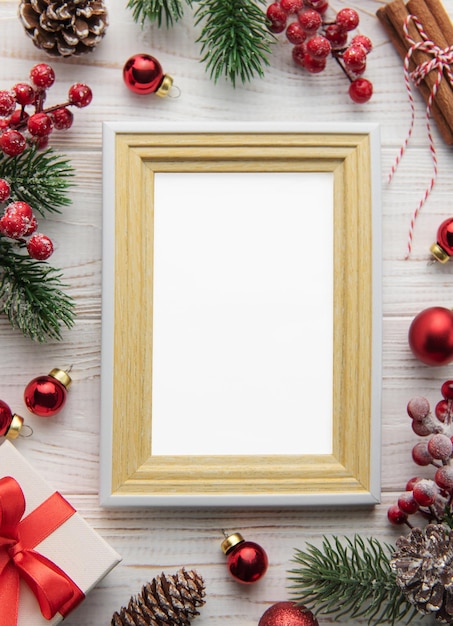 Photo frame decorations fir tree branches on white wooden background