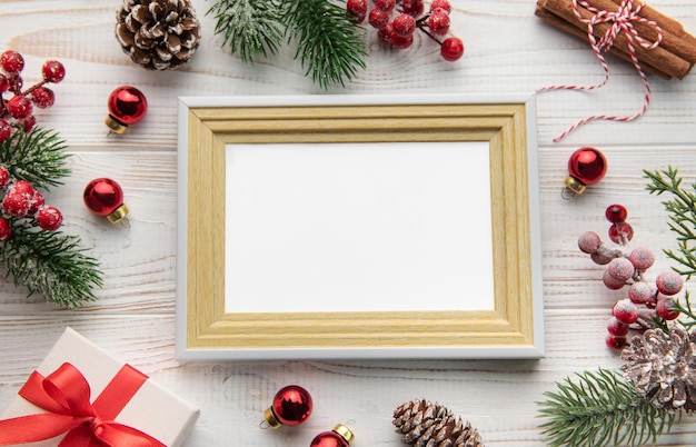 Photo frame decorations fir tree branches on white wooden background