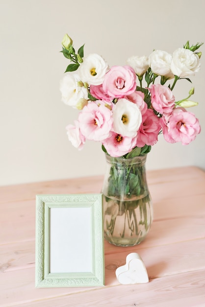 photo frame and flowers in a vase on the table