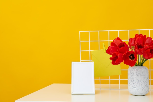 Photo frame on the table with flowers and letters