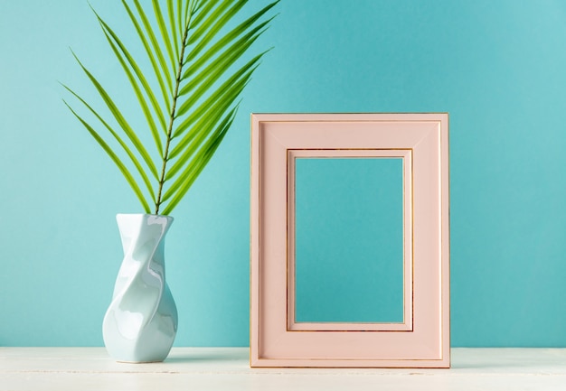 Photo frame and tropical leaf in vase
