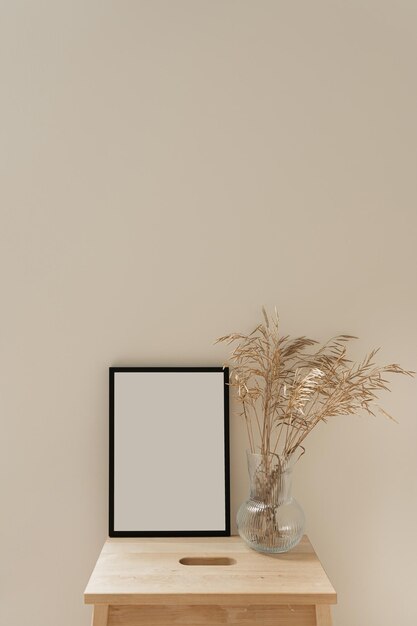 Фото Фотокадра с пустым макетом копирования пространства сушеные стебли травы букет в стеклянной вазе на нейтральном бежевом фоне эстетический минимальный дизайн интерьера дома украшение