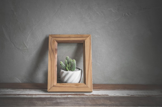  photo frame with cactus flower on wood table 