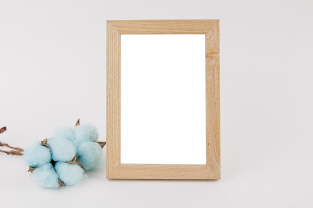 Photo frame with cotton flower decor on white background