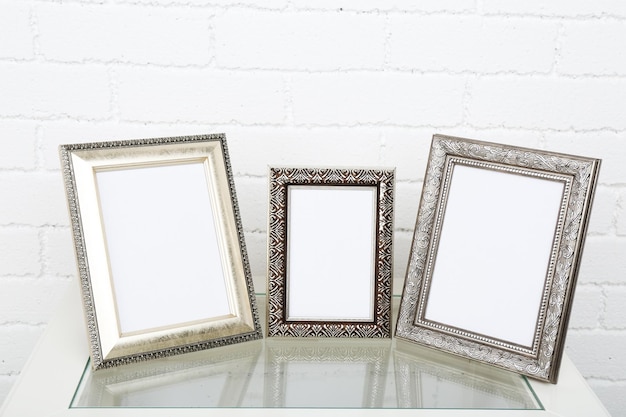 Photo frames on coffee table on brick wall background