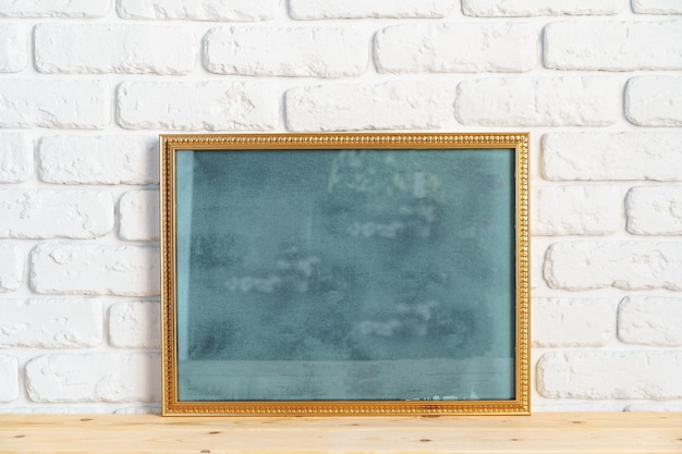 Photo frames on floor over white brick wall