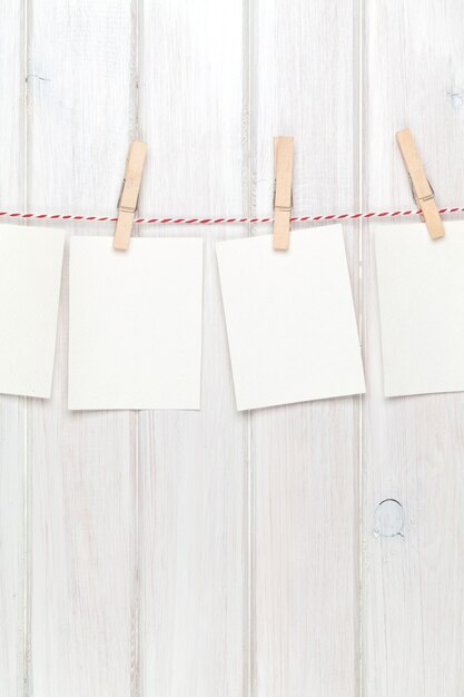 Photo photo frames hanging on rope over white wooden background