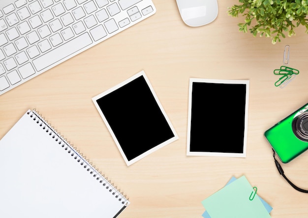 Photo photo frames on office table with notepad computer and camera