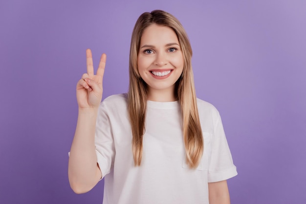 Photo of friendly funny lady show v-sign wear casual clothes on violet background