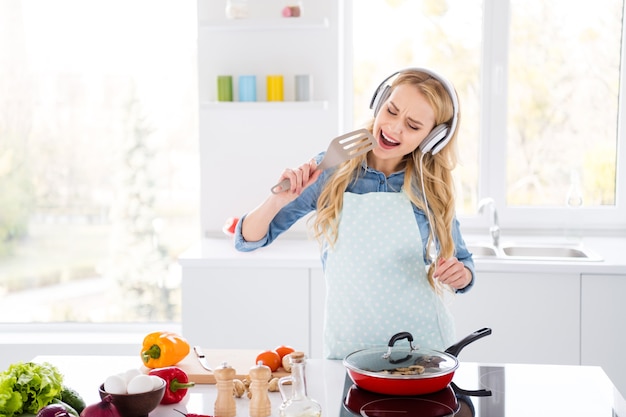 Photo of funny housewife blond lady cutting salad cooking tasty dinner