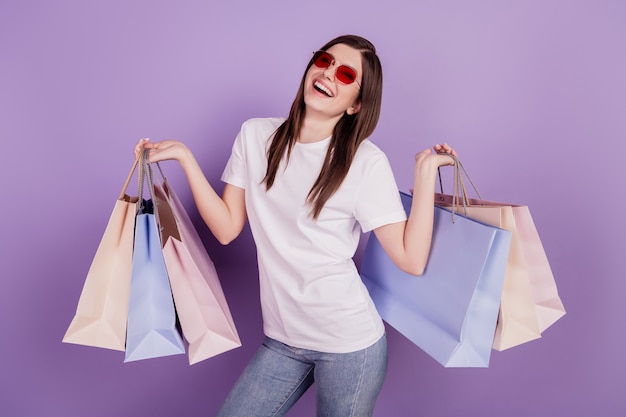 Photo of funny lady enjoy carry shopping packs isolated violet background