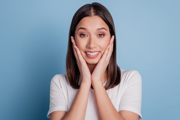 Photo of funny nice attractive dream lady palm cheeks look camera glad face on blue background