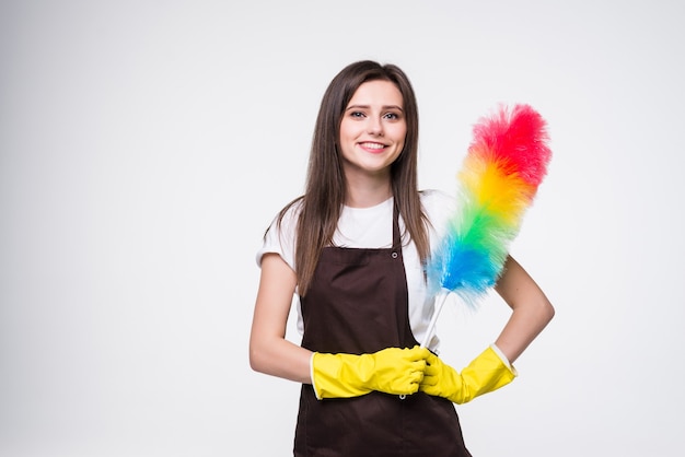 Photo of funny woman 20s wearing yellow rubber gloves for hands protection holding colorful duster while cleaning room isolated