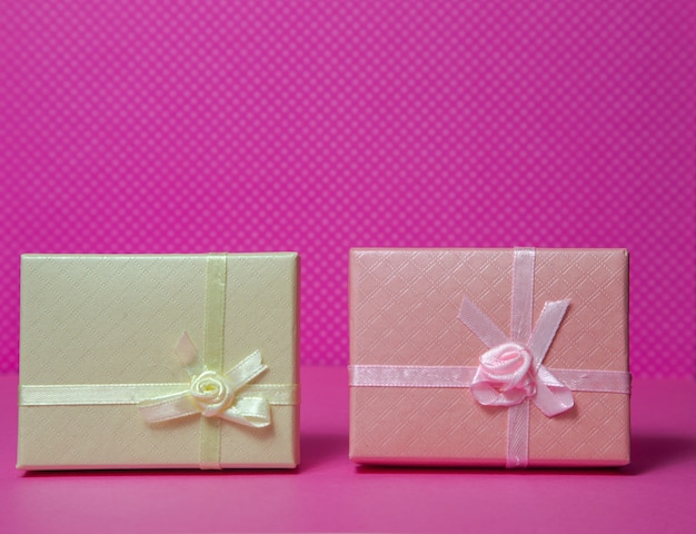 Photo of a gift box with a bow under different points of view on a pink background front view