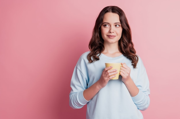 Photo of girl hold cup drink coffee look side empty space think inspiration pause concept