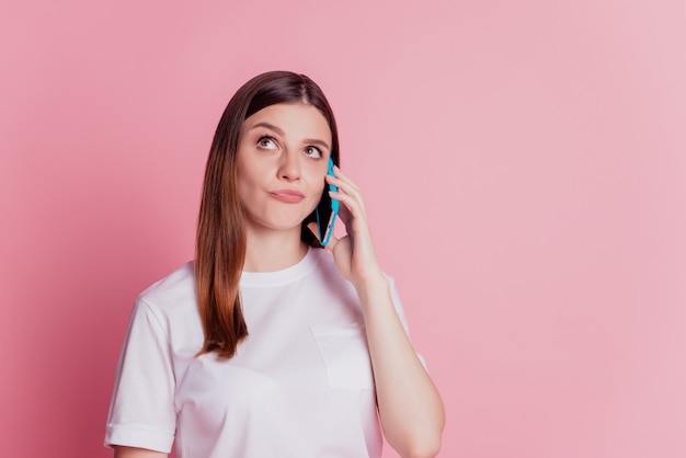 Photo of girl use mobile phone look up empty space communicate have doubts