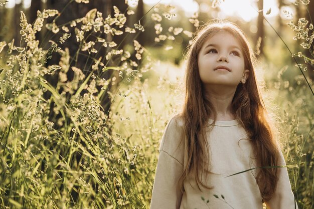 photo of a girl walking on the last warm summer days in a park with tall grass