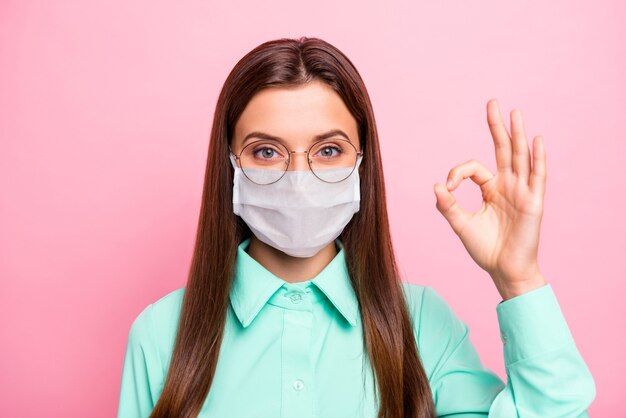 Photo of girl wearing face mask show okay sign on pink background