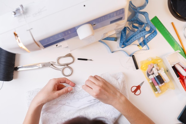 Photo of girl with sewing accessories on background of sewing machine