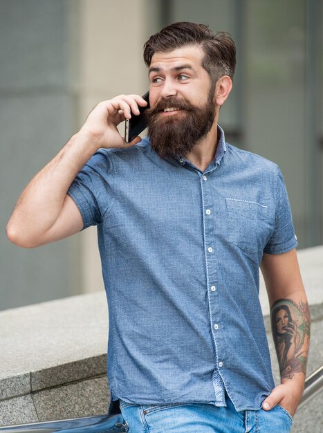 스마트폰으로 이야기하는 기쁜 남자의 사진 야외에서 스마트폰으로 이야기하는 남자 야외에서 스마트폰으로 이야기하는 남자 거리에서 스마트폰으로 이야기하는 남자