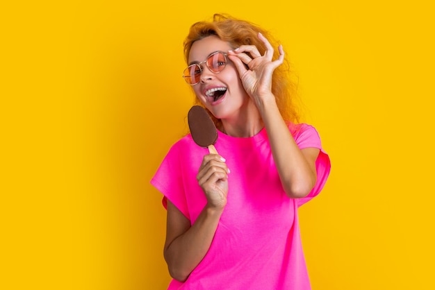 Photo photo of glad woman with icelolly ice cream at summer woman with icelolly ice cream isolated on yellow woman with icelolly ice cream in studio woman with icelolly ice cream on background