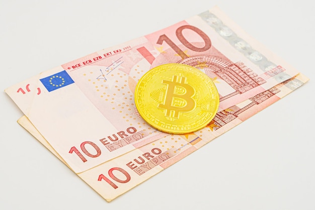 photo of golden bitcoins new virtual currency with traditional dollars and euro as a background bitcoin to euro crypto concept Bitcoin in Europe