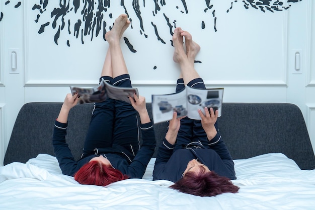 a photo of a grandmother reading a fashion magazine and laughing with their teen granddaughter